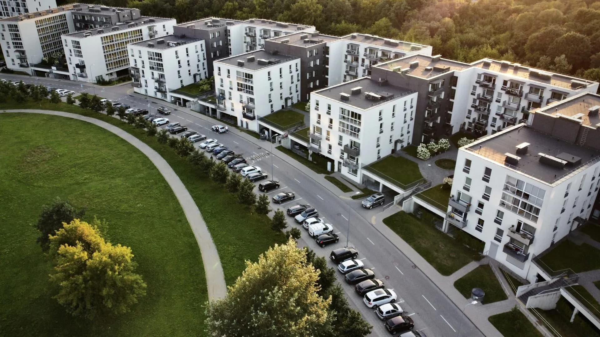 Aerial view of a modern apartment complex with lawns and trees